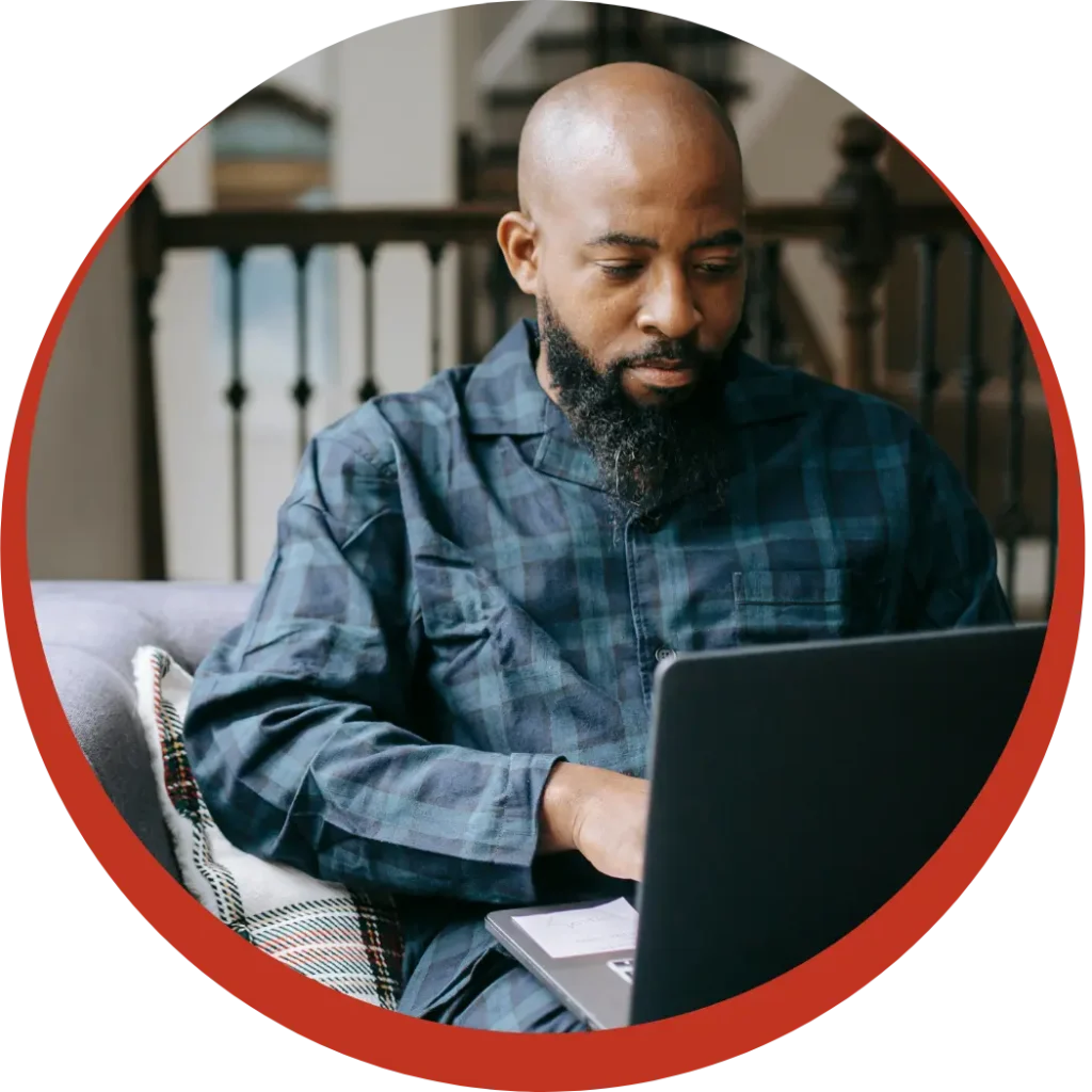 African man sitting on couch at home making an NDIS referral