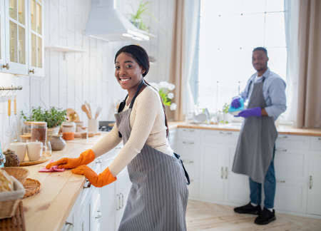 Two support workers cleaning kitchen