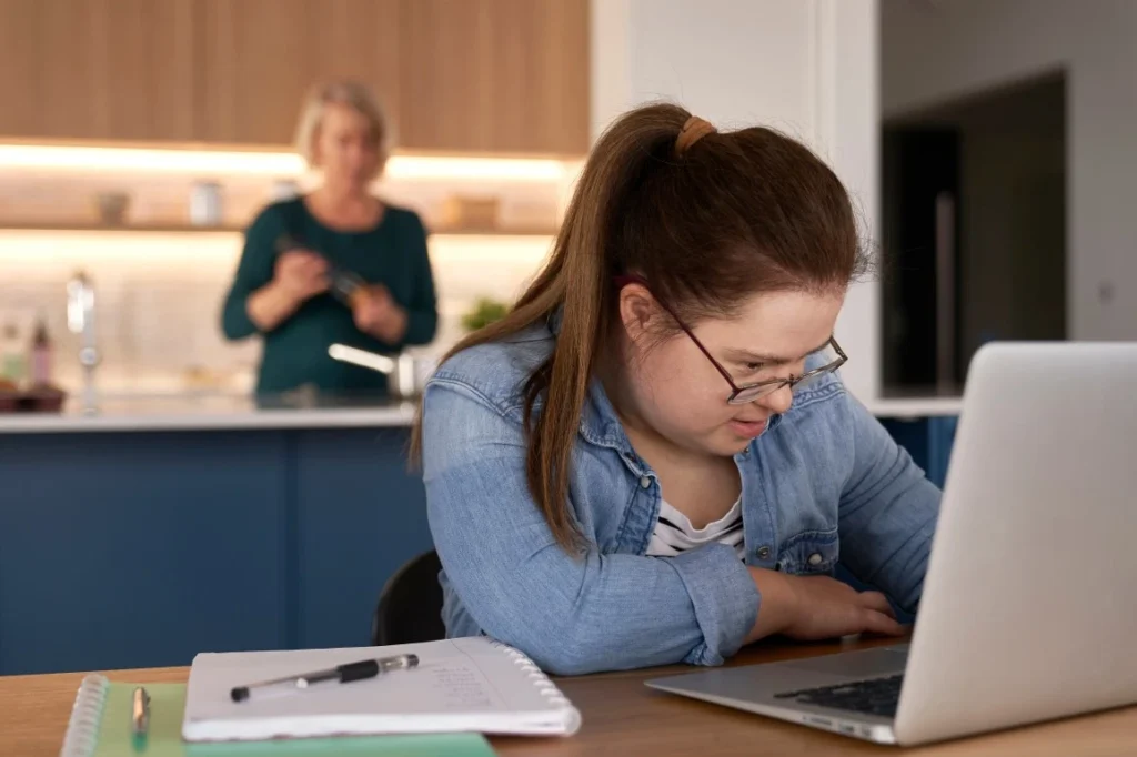 Disabled girl with down syndrome learning on laptop