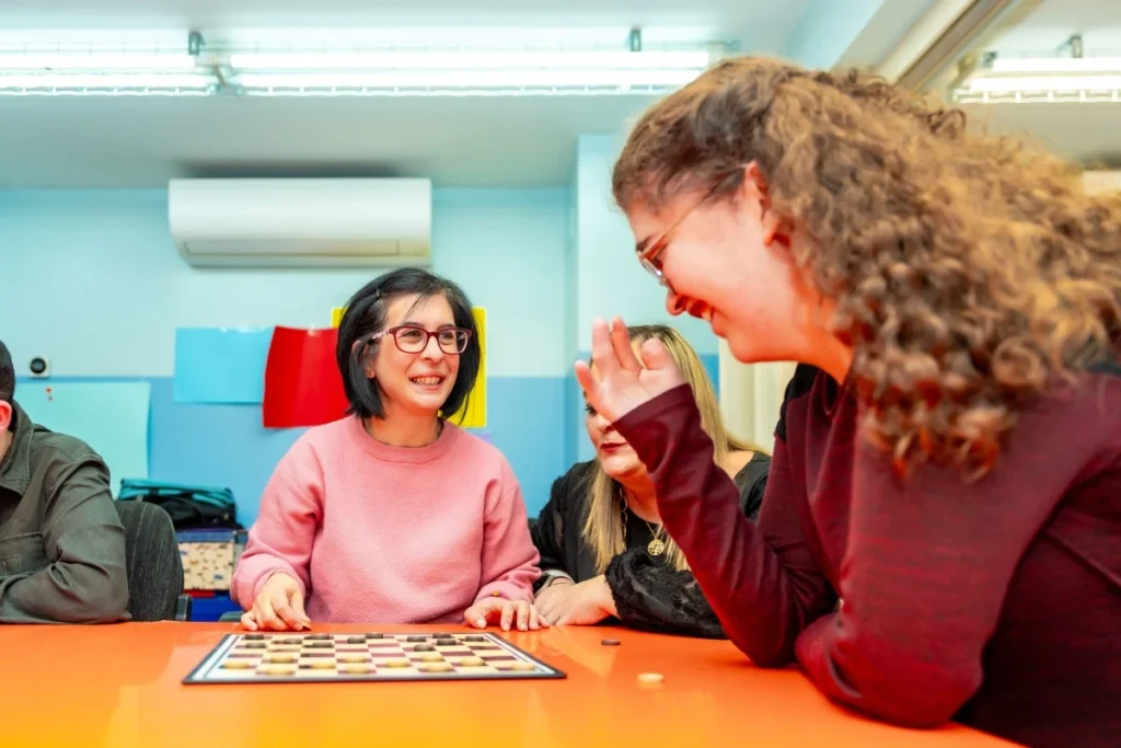 Two disabled friends playing checkers at a community centre